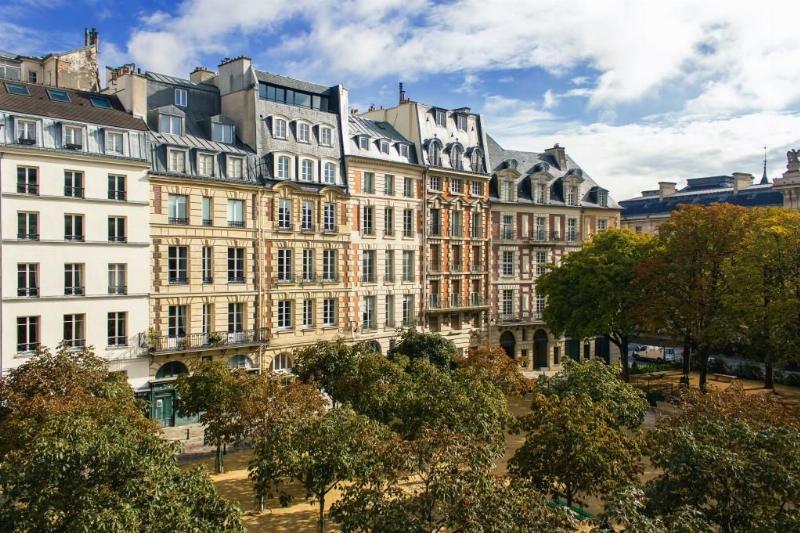 La cathédrale Notre-Dame de Paris après restauration, avec des piétons l'admirant depuis le parvis