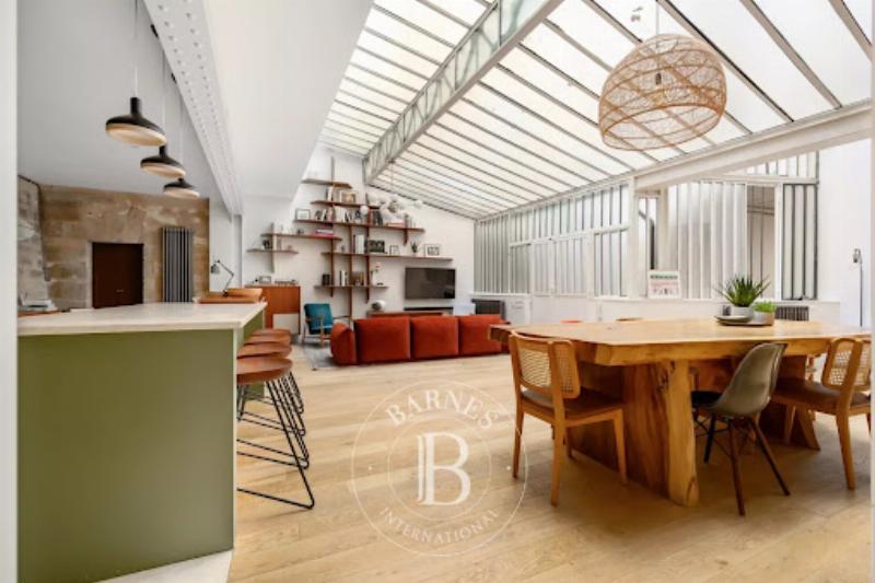 Vue panoramique d'un large boulevard haussmannien à Paris avec des immeubles majestueux