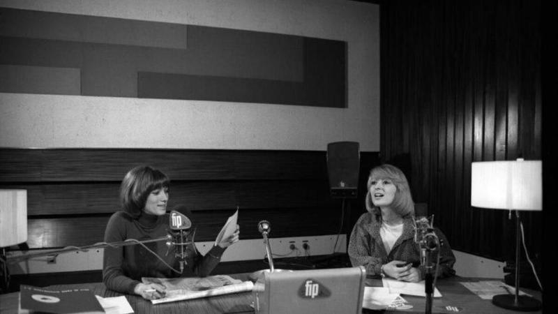 Une femme écoute une station de radio musique classique paris dans un appartement parisien élégant