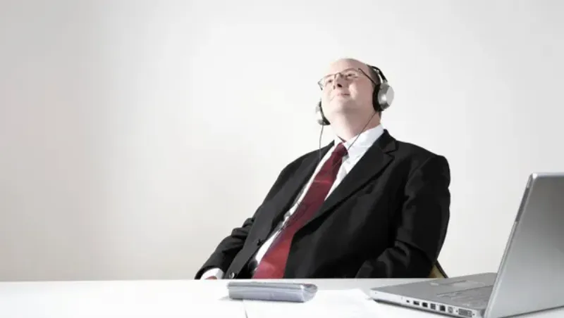 Une personne absorbée par la lecture d'un livre musical de musique classique, écoutant avec un casque