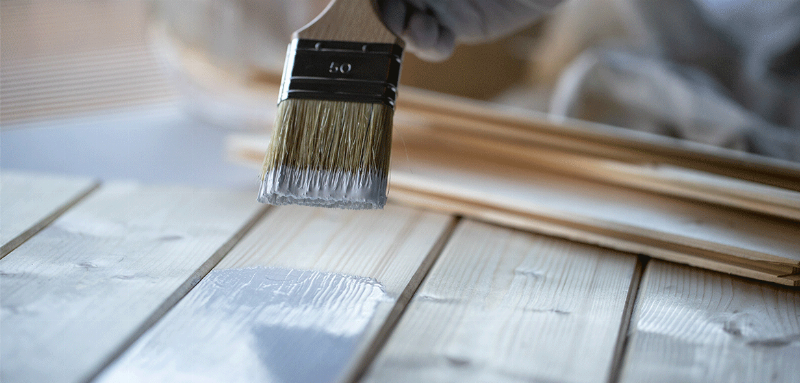 Peintre professionnel appliquant de la peinture laquée blanche sur des boiseries