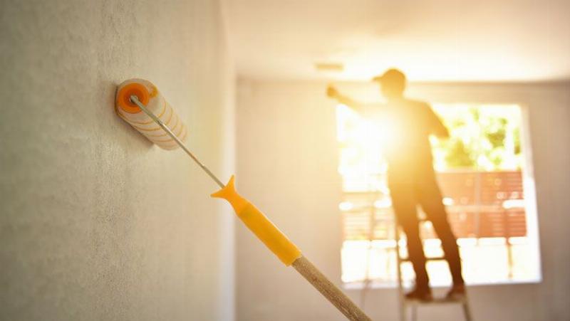 Peintre professionnel utilisant une perche télescopique 4m pour un plafond haut, avec une technique impeccable