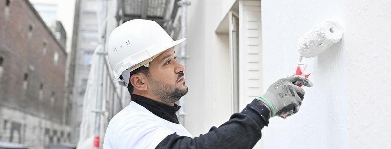 Application de peinture façade professionnelle sur une maison française par un expert