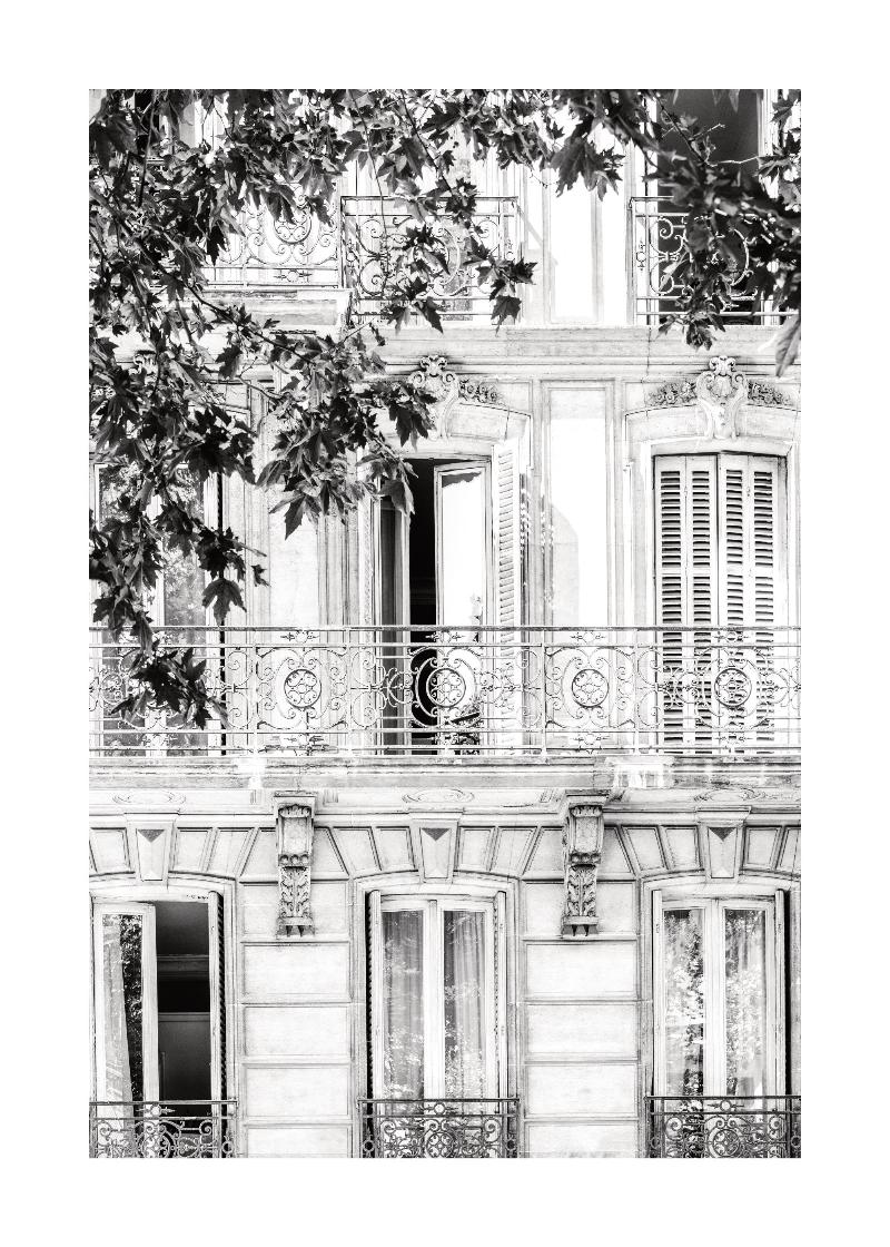 Balcon parisien en fer forgé peint en vert avec fleurs luxuriantes