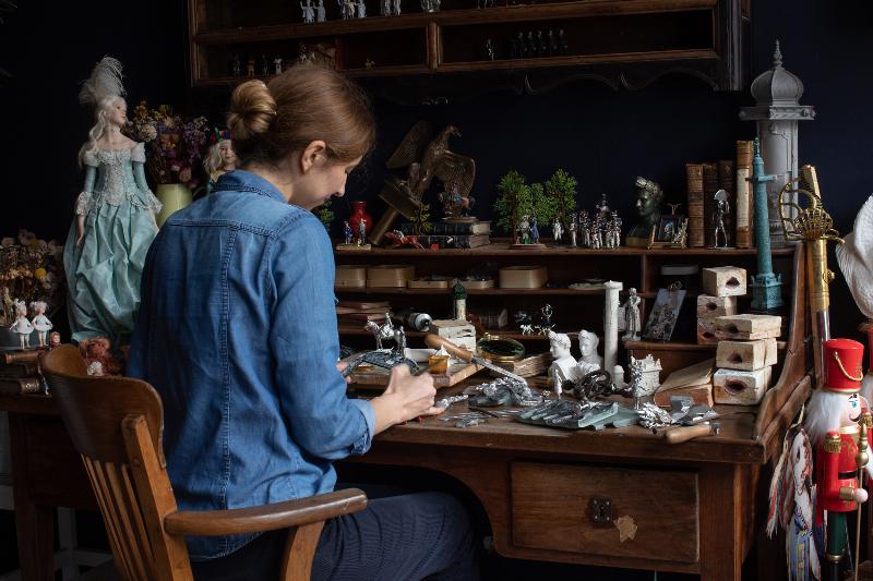 Peinture de figurine dans un atelier français, mettant en valeur la précision et la passion pour l'artisanat