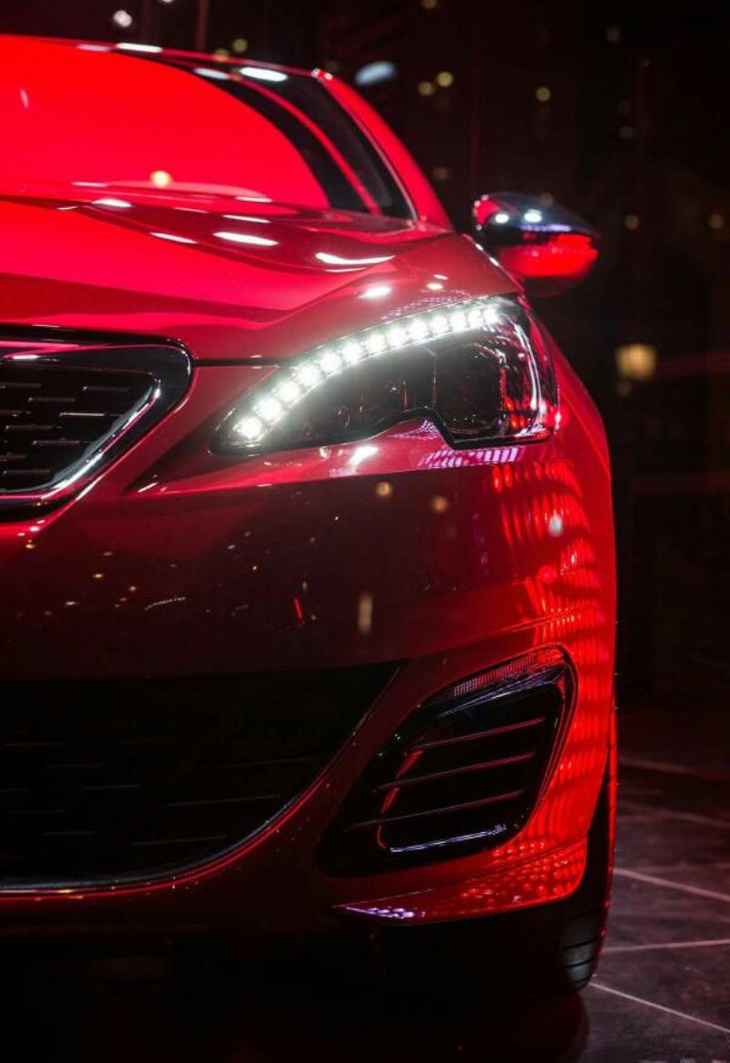 Une berline française élégante avec une peinture grise métallisée, reflétant la lumière du soleil, symbolisant le design et la modernité. 