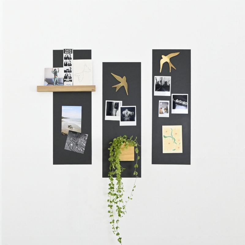 Un mur de cuisine moderne avec une peinture noire tableau magnétique, affichant des recettes et des notes familiales avec des aimants.