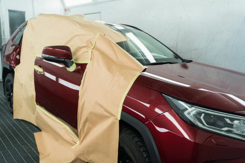 Préparation minutieuse d'une surface plastique extérieure de voiture avant peinture, étape clé pour une adhérence optimale