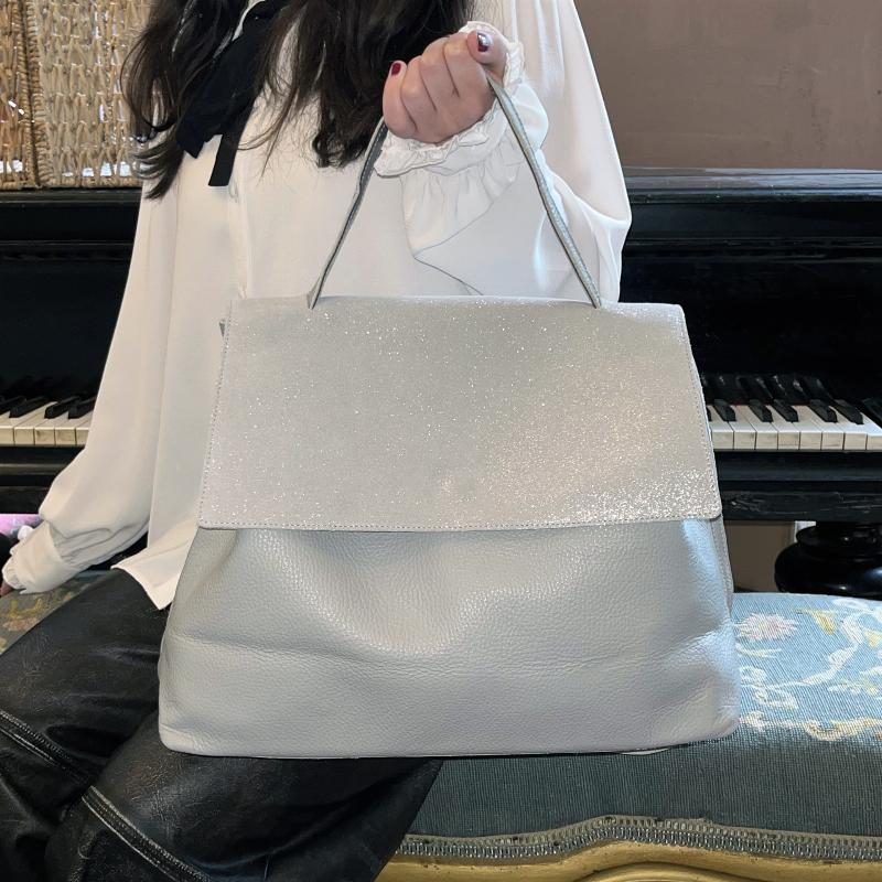 Sac à main de luxe en daim peint, porté par une femme parisienne élégante