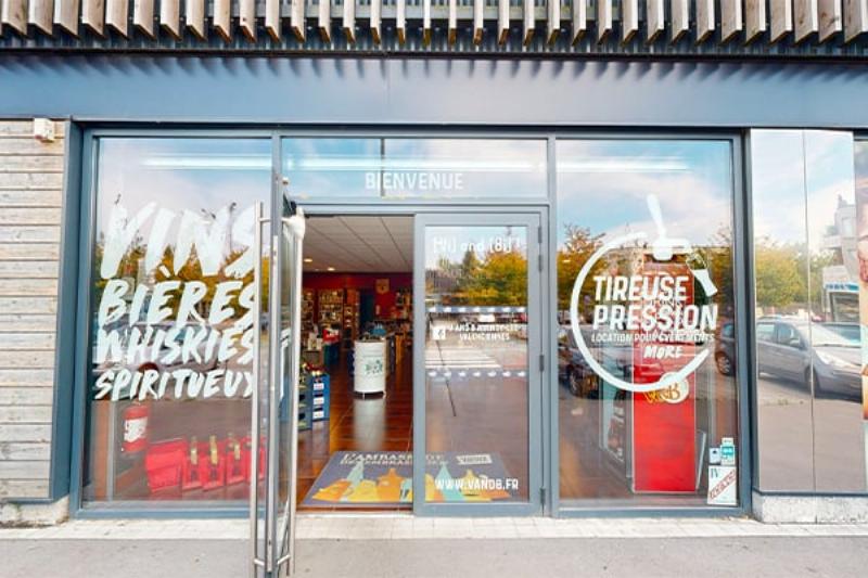 Une ancienne commode en bois peinte avec une patine subtile, reflétant l'art du relooking de meubles à la française, avec des pinceaux et des pots de peintures pour meubles en bois à côté.