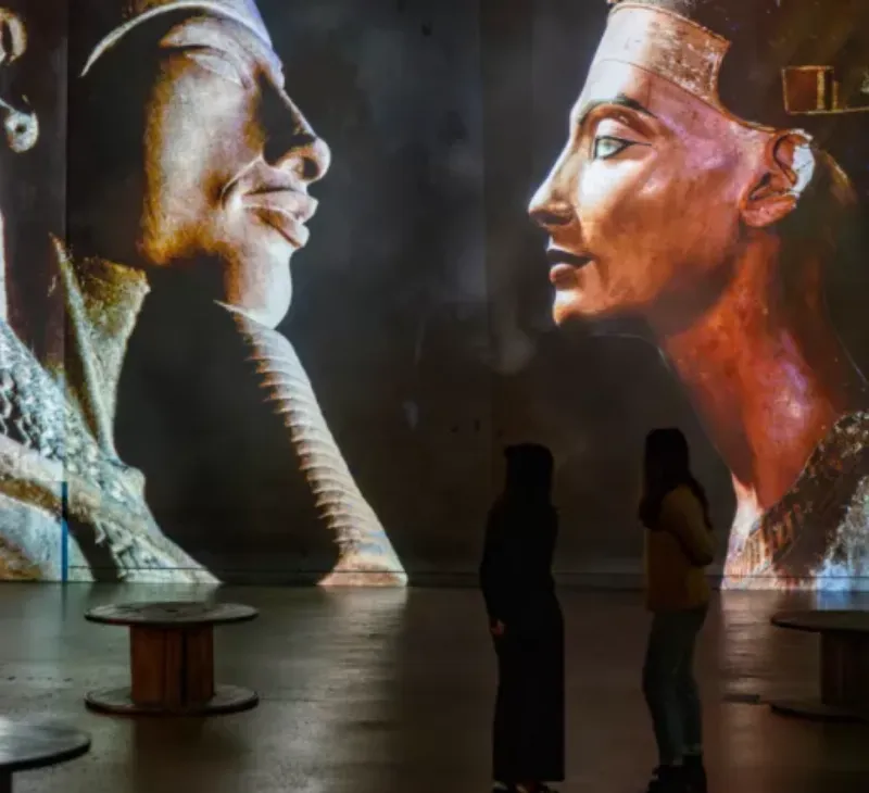 Majestueuse pharaon statue égyptienne antique en granit, symbolisant le pouvoir divin et royal des pharaons, avec des hiéroglyphes et une coiffe traditionnelle.