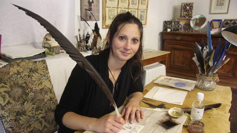 Une main habile utilisant une plume d'oie pour une enluminure médiévale, détails fins de la plume peinture