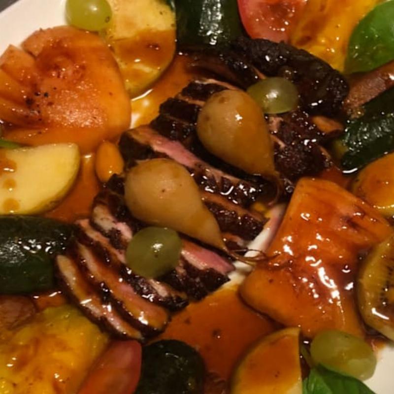 Un grand repas de famille festif en France, avec des plats traditionnels généreusement servis sur une table élégamment dressée.