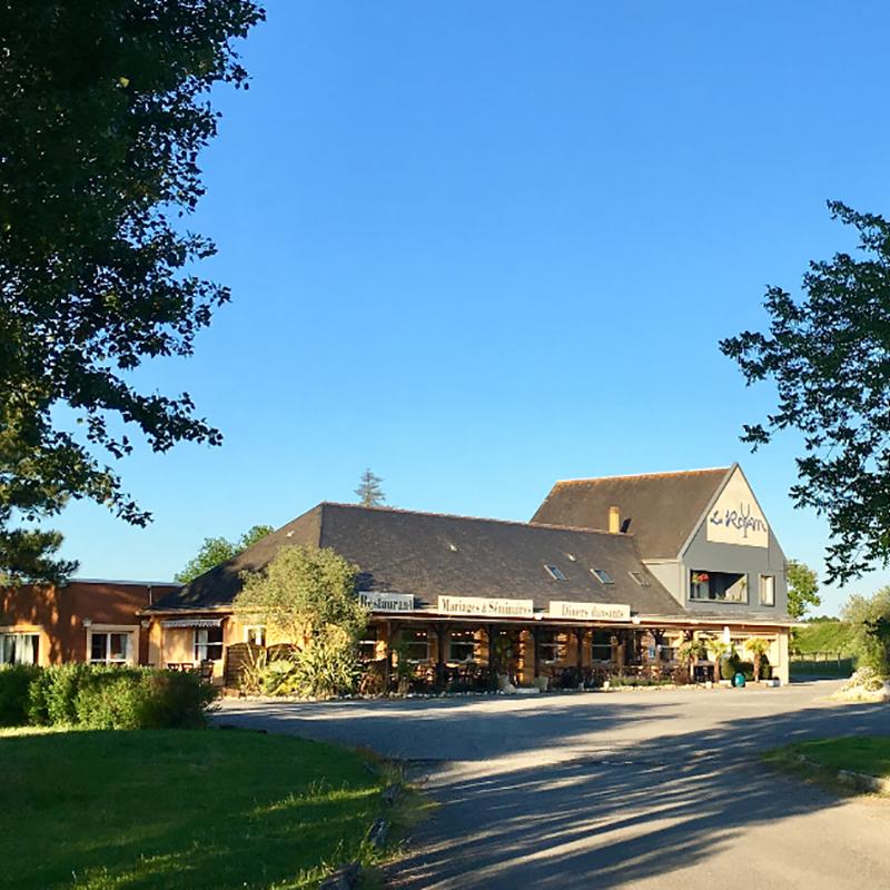 Une grande table dressée pour un repas de fêtes de famille traditionnel français, avec des plats gastronomiques, du vin et une atmosphère chaleureuse.