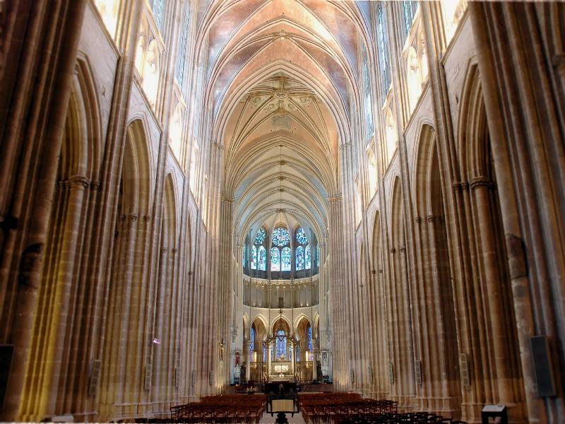 Lumière filtrant à travers les vitraux de Notre Dame de Paris, créant une atmosphère mystique
