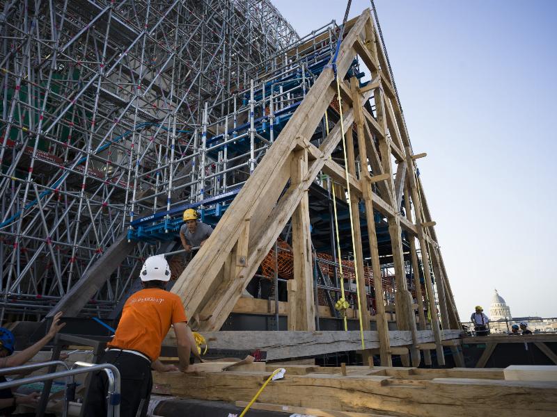 Des artisans spécialisés travaillant sur la restauration de Notre-Dame de Paris avec des techniques traditionnelles
