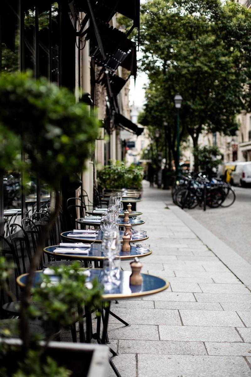 Ambiance d'une rue parisienne avec des passants et des terrasses de café