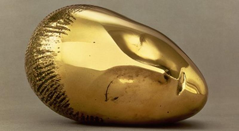 Un artiste contemporain français travaillant une sculpture abstraite dans son atelier, utilisant des outils modernes et traditionnels.