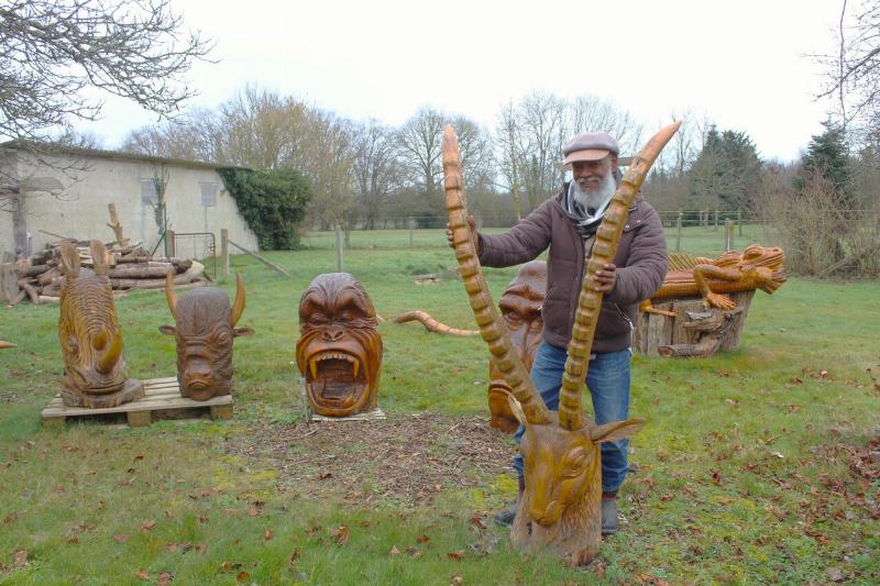 Artiste sculpteur bois à la tronçonneuse en pleine création, détaillant une œuvre avec précision et passion