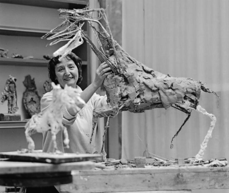 Une sculpture de cheval en bois contemporaine, stylisée et abstraite, exposée dans une galerie.