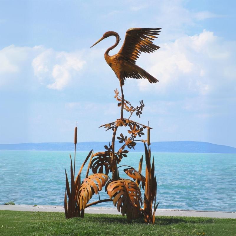 Sculpture moderne en métal rouillé dans un jardin luxuriant