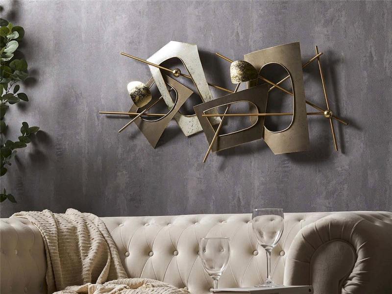 Sculpture murale contemporaine abstraite en métal reflétant la lumière sur un mur moderne