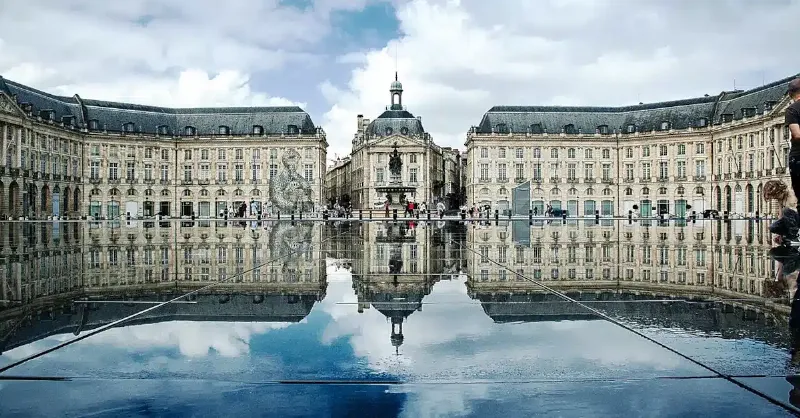 Sculpture moderne et imposante d'un pouce dans un espace public français, avec une foule de personnes l'admirant.