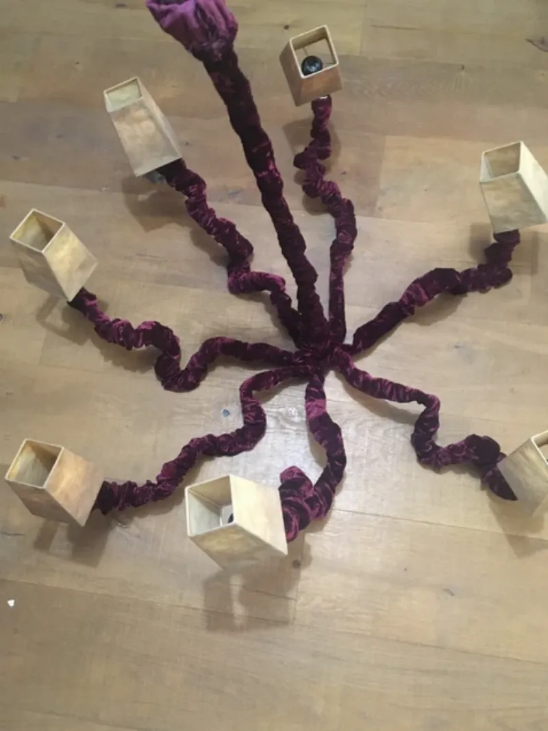 Une artiste féminine sculpte une forme complexe dans le sable compacté à l'aide d'outils de précision sur une plage ensoleillée, mettant en lumière la patience et la technique de la sculpture sur sable.