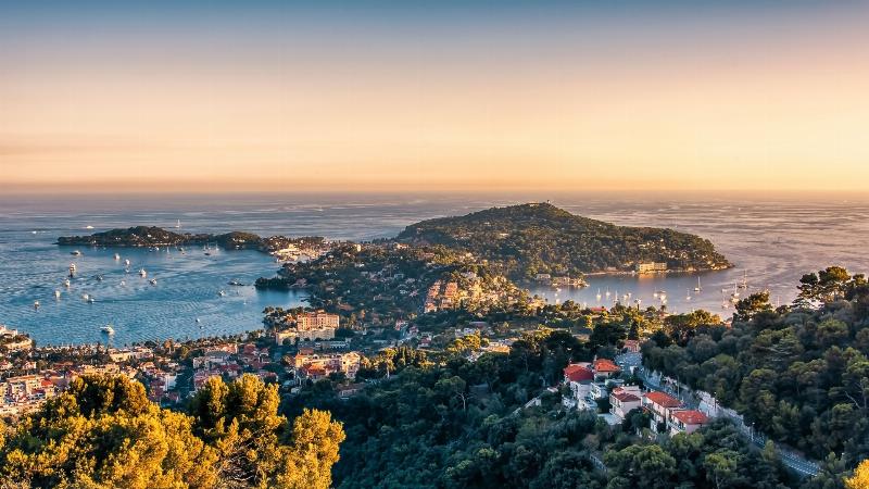 Vue panoramique du sentier Le Corbusier le long de la Côte d'Azur, avec la mer Méditerranée au loin, reflétant le patrimoine architectural et naturel.