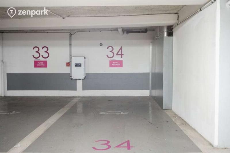Intérieur moderne d'un parking souterrain sécurisé près de Notre-Dame à Paris, avec de nombreuses places disponibles et une signalisation claire