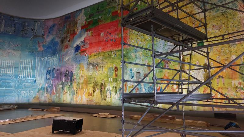 Un artiste français travaillant sur une peinture mettant en valeur la lumière, une caractéristique clé de l'art plastique français