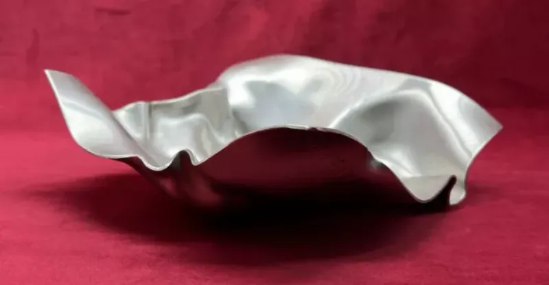 Une personne appliquant méticuleusement une perle de résine sur une toile de broderie diamant avec un applicateur spécial. 