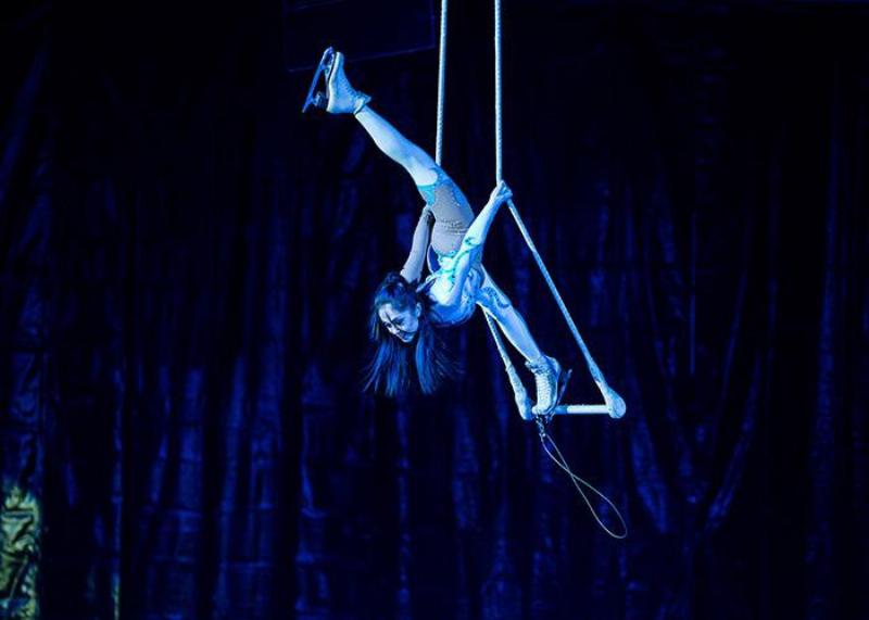 Une artiste moderne interprète une chanson française sur scène, illuminée par des lumières douces, captivant son public avec son émotion et son talent unique, incarnant le renouveau du genre