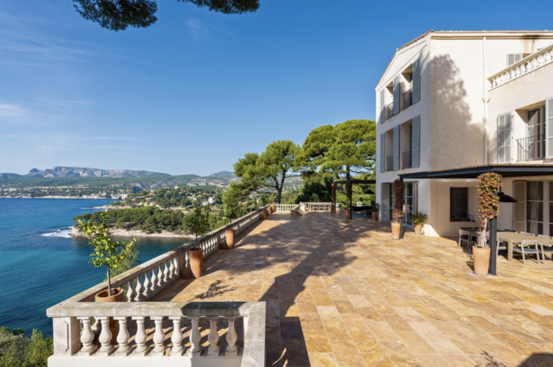 Façade vitrée d'une villa moderne architecture avec piscine à débordement et vue sur la nature
