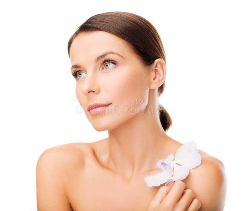 Une femme écoute de la musique classique gratuite sur YouTube avec des écouteurs, souriante et détendue.