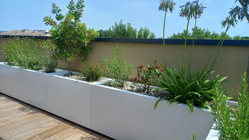 Abri de jardin traité à la lasure, aspect bois naturel, intégré dans un jardin à la française