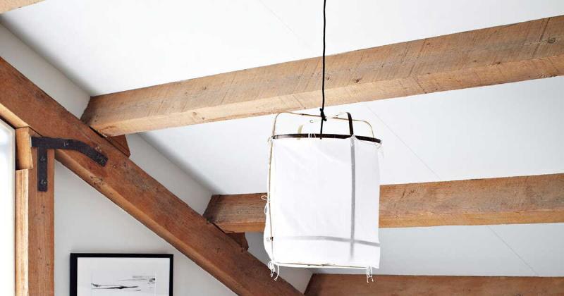 Peinture bois blanc laqué sur meuble ancien dans un salon cosy. Style français authentique.