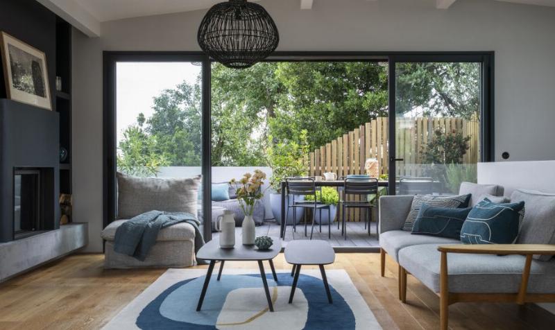 Décoration intérieure d'un salon moderne de 50m² avec des murs fraîchement peints en couleurs douces, ambiance chaleureuse et lumineuse. Style contemporain français.