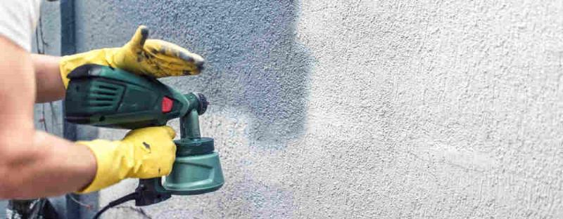 Application de peinture sur un crépi extérieur avec un rouleau à poils longs, technique de croisement des passes