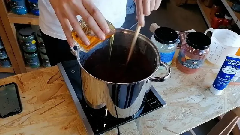 Application de peinture blanche sur une poutre en bois avec un pinceau, style artisanal français