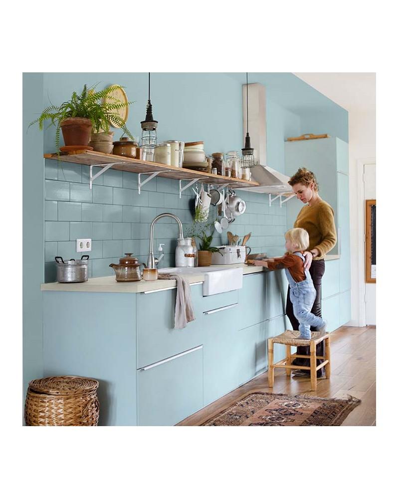 Un peintre applique délicatement de la peinture murale dans une salle de bain moderne, utilisant des outils de qualité.