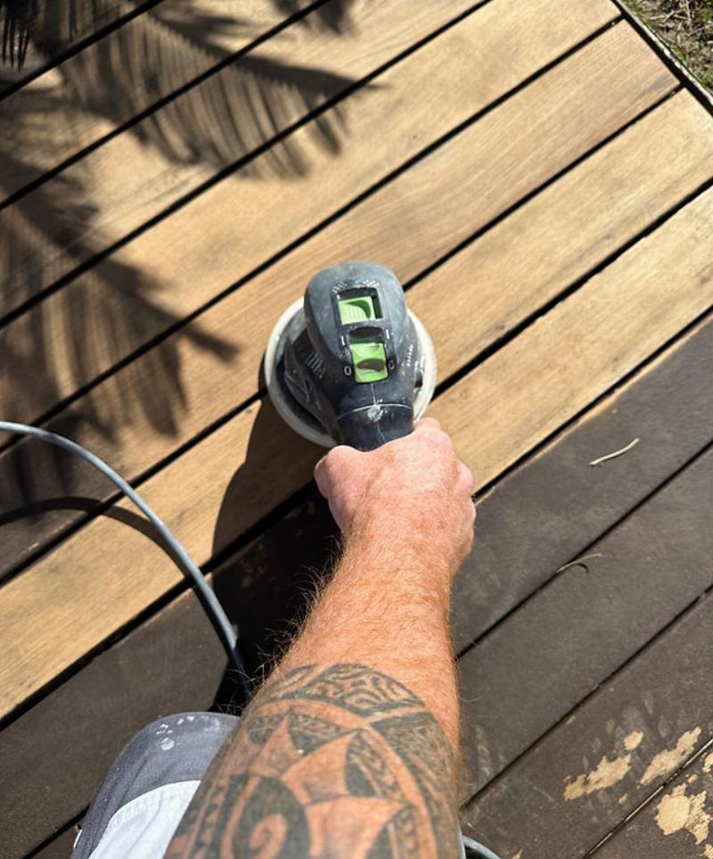 Application méticuleuse de peinture vert canard sur un mur, montrant la technique du rouleau pour une finition sans traces