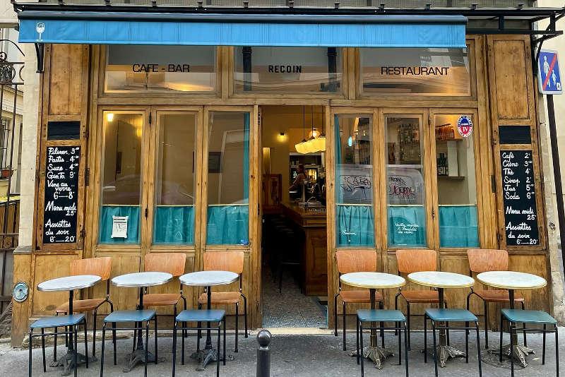 Ambiance chaleureuse d'un bar parisien avec éclairage tamisé et mobilier vintage