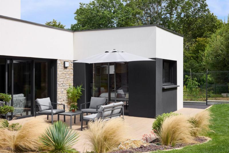 Maison moderne s'intégrant dans un paysage verdoyant avec panneaux solaires