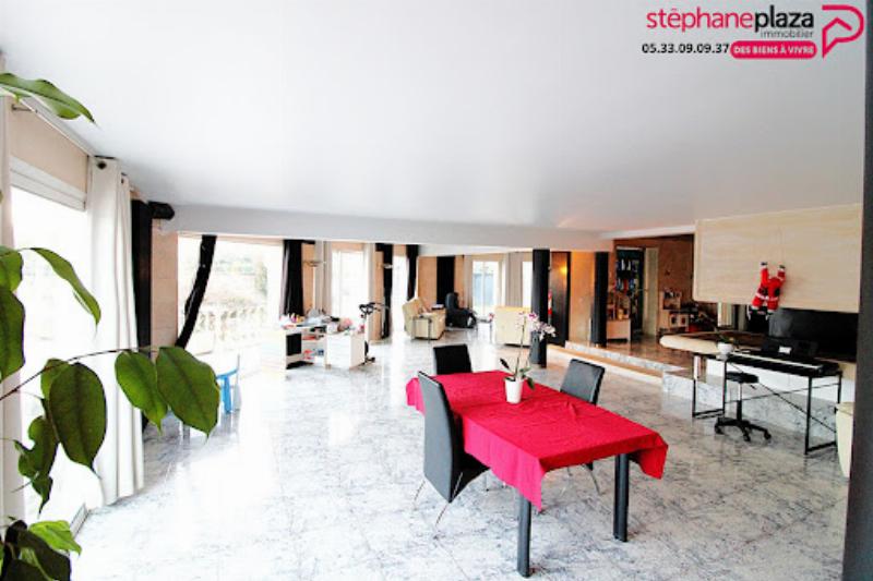 Maison d'architecte moderne avec de grandes baies vitrées et un jardin paysager à la française