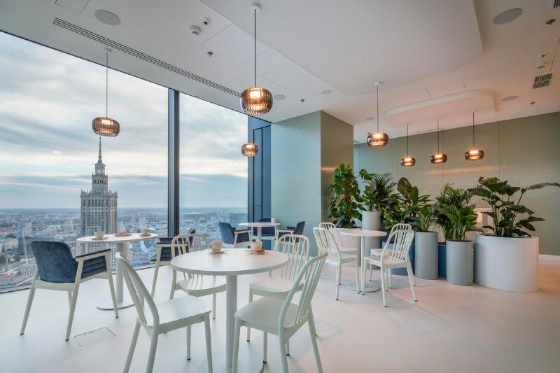 Architecture moderne d'un espace de travail ouvert et lumineux avec des zones de collaboration et des plantes vertes