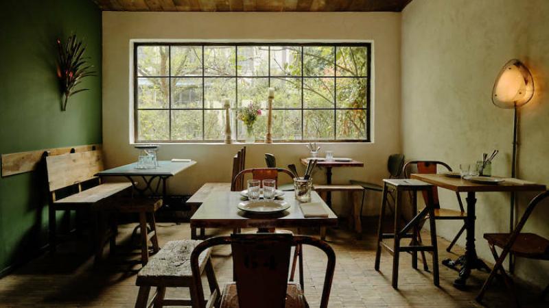 Une peinture naïve détaillée d'une cuisine française traditionnelle, mettant en scène des ingrédients frais et une atmosphère chaleureuse.