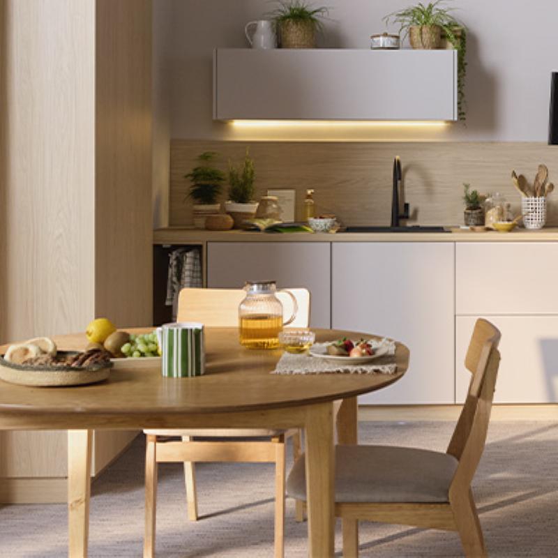 Une salle de bain combinant peinture vert sauge, carrelage métro blanc, meuble en bois naturel et robinetterie en laiton.