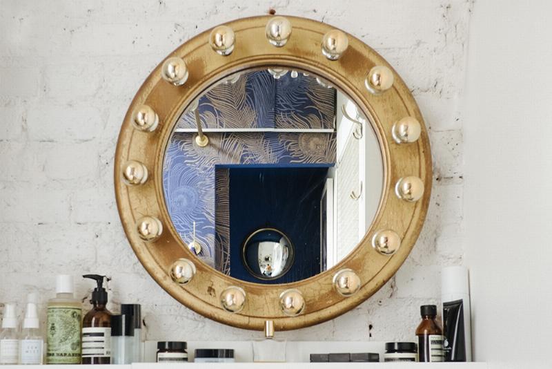 Décoratrice d'intérieur française examinant un carrelage peint avant rénovation, avec une palette de couleurs douces