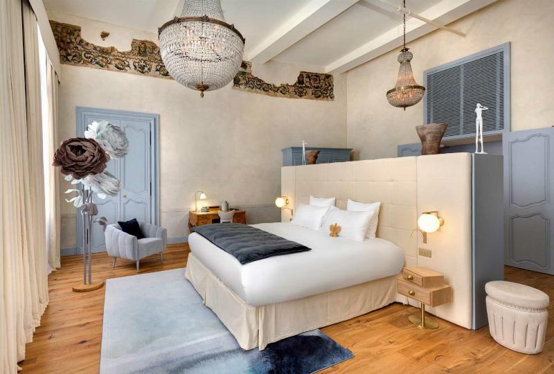 Intérieur d'un salon élégant de style architectural Cap, avec des meubles classiques, des détails en dorure et une grande fenêtre donnant sur un jardin.